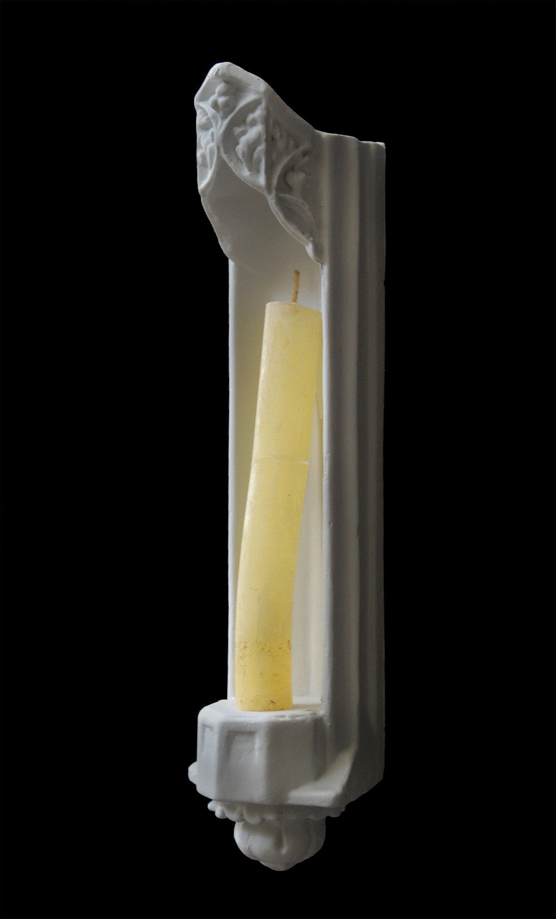image of a plaster statue of a bust of gothic sconce with candlestick on a black background