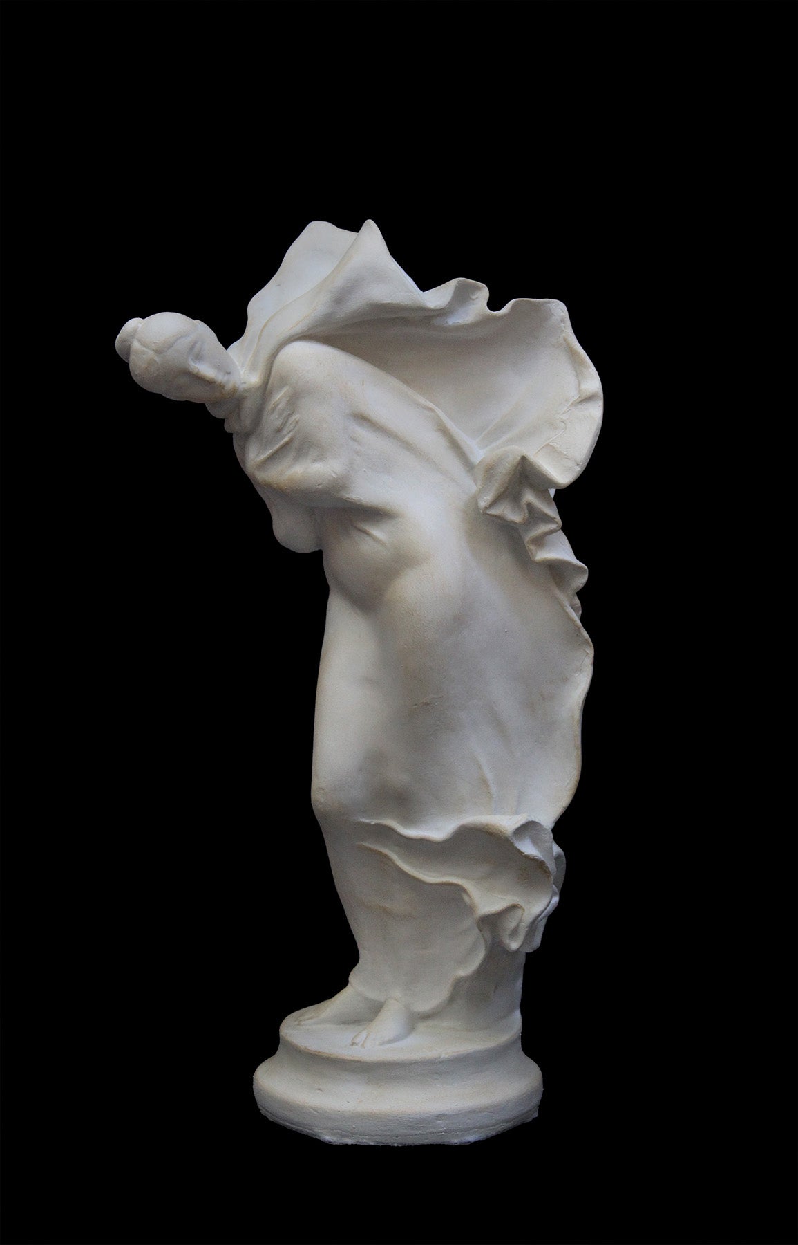 image of a plaster statue of a bust of dancer on a black background
