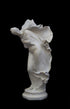 image of a plaster statue of a dancer with flowing drapery on a black background
