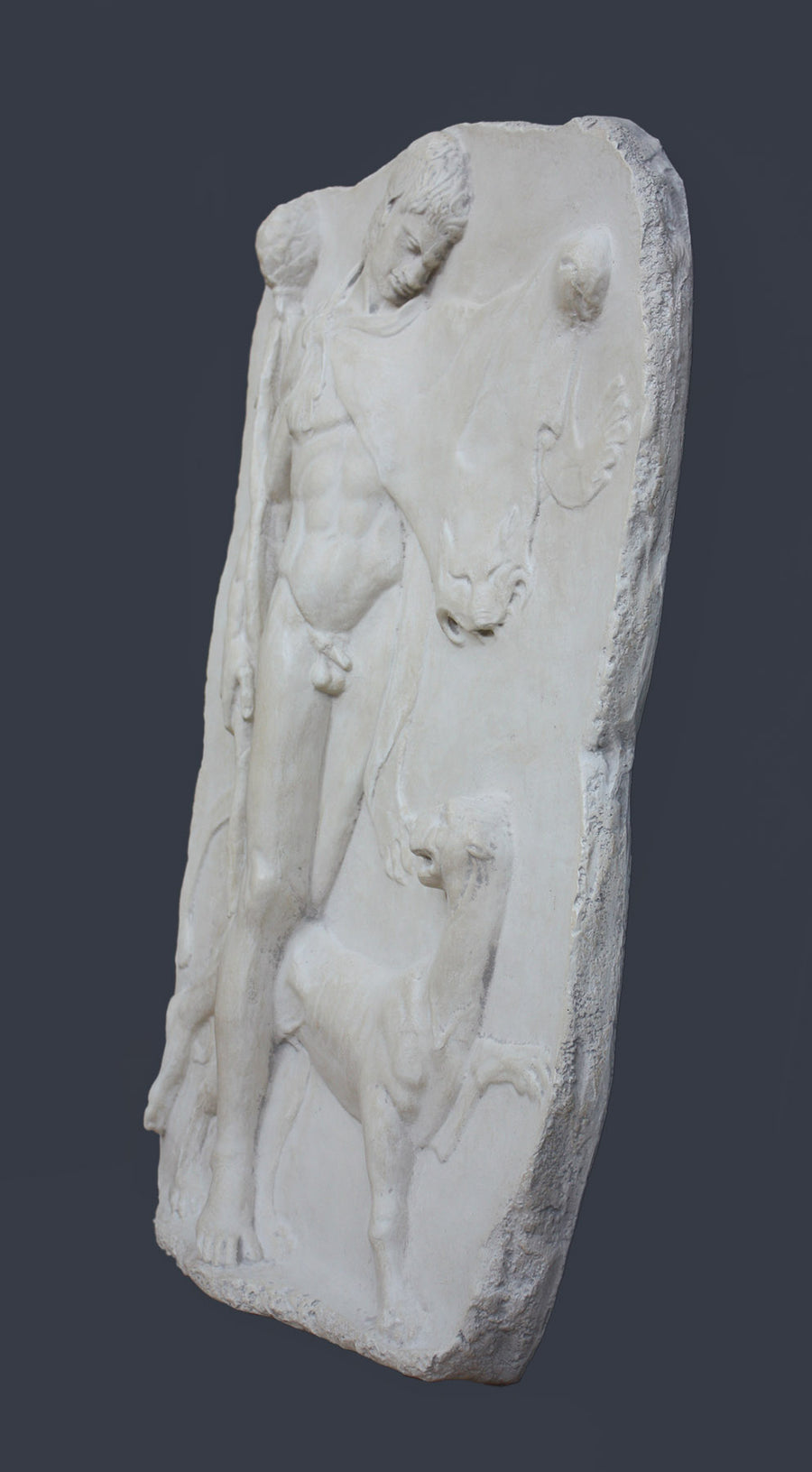 side photo of white plaster cast relief sculpture of satyr with animal skin over his arm and staff in one hand walking beside a panther against gray background