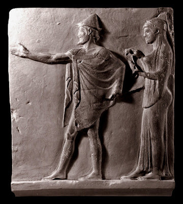 photo of plaster cast sculpture relief of two figures walking to the left, the male reaching out his right hand and the female behind him