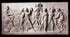 Photo of plaster cast sculpture relief of nude and clothed females (muses) dancing and playing instruments and one male (Apollo) playing a lyre on a black background