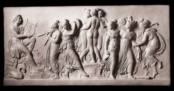 Photo of plaster cast sculpture relief of nude and clothed females (muses) dancing and playing instruments and one male (Apollo) playing a lyre on a black background