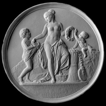 black and white photo of white plaster cast relief sculpture of mostly nude female figure with two children and flowers and wreaths against black background