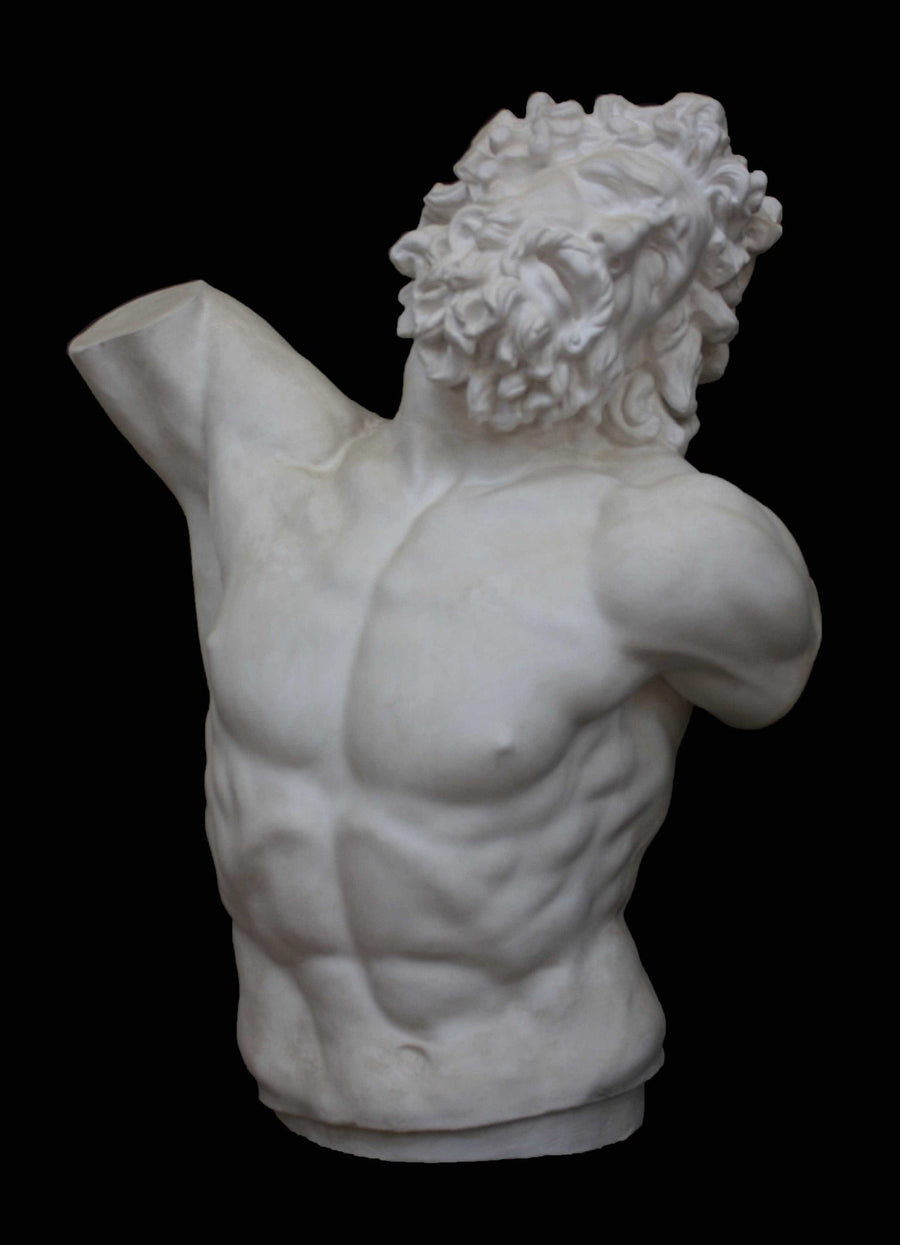 photo with black background of plaster cast sculpture of male torso and head with curly hair and beard, namely Laocoon