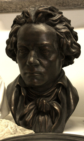 photo of bronze-colored plaster cast sculpture bust of man, namely Beethoven, with neckerchief on light-colored background