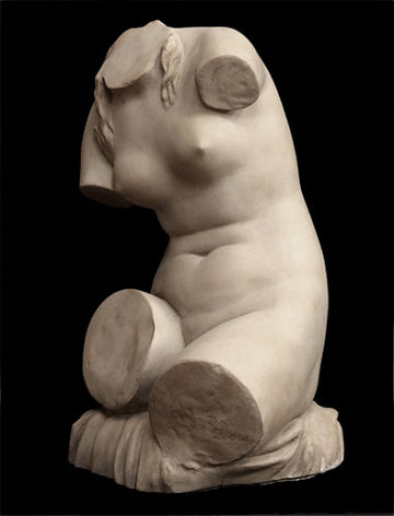 photo with black background of plaster cast sculpture of female torso seated