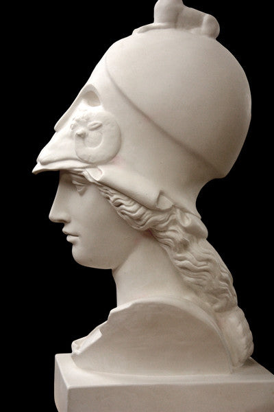 photo of plaster cast sculpture bust of female head, namely the goddess Athena, with a helmet on a black background