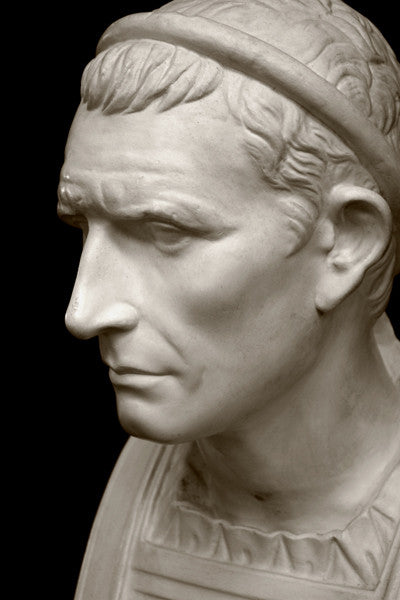 closeup photo with black background of plaster cast bust sculpture of a man, namely Antiochus III, with headband and clothing on the square bust