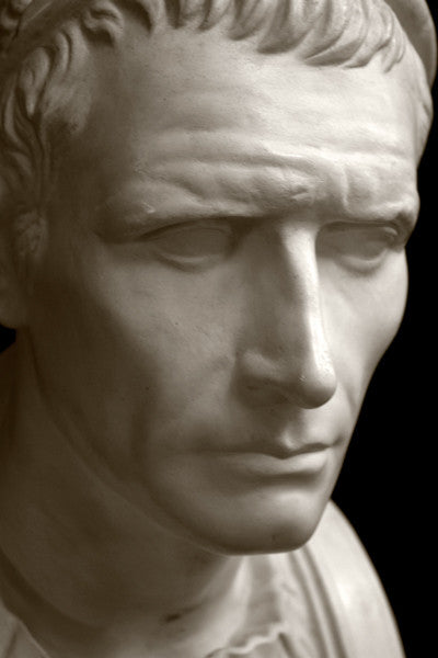 closeup photo with black background of plaster cast bust sculpture of a man, namely Antiochus III, with headband and clothing on the square bust