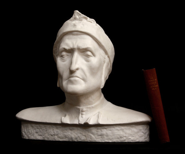 photo of plaster cast bust sculpture of Dante Alighieri with cap and high-necked robe with red book leaning against right side on black background