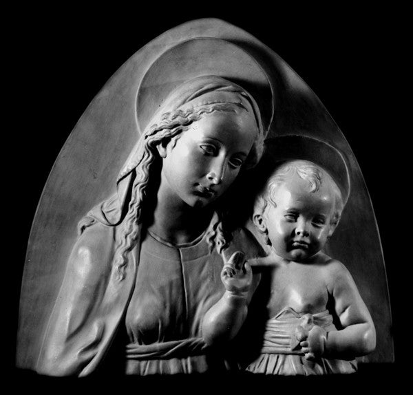 Photo of plaster sculpture of Madonna and Child on a black background