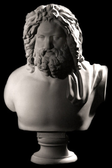Photo with black background of plaster cast sculpture of male bust, namely the god Zeus, with curly hair and beard and robe over left shoulder