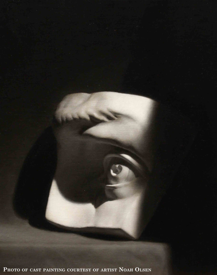 Photo of cast painting of plaster cast of eye on a gray shelf and black background