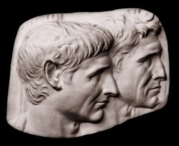 photo of plaster cast sculpture relief of two male heads with a black background