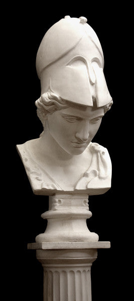 photo of plaster cast sculpture bust of female head, namely the goddess Minerva, with a helmet and looking down and placed on a pedestal with black background