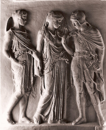 photo with gray background of plaster cast of ancient relief with three figures, namely Hades, Eurydice, and Orpheus