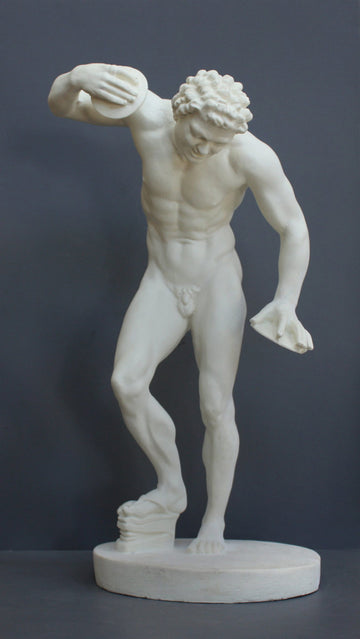 Photo with gray background of plaster cast sculpture of male faun or satyr dancing with instruments attached to his hands