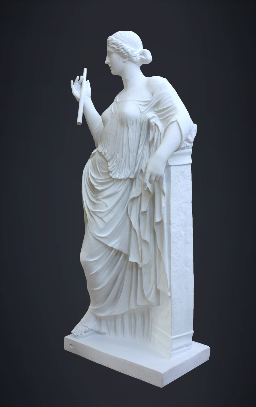 photo of plaster cast sculpture of female figure in robes leaning on podium