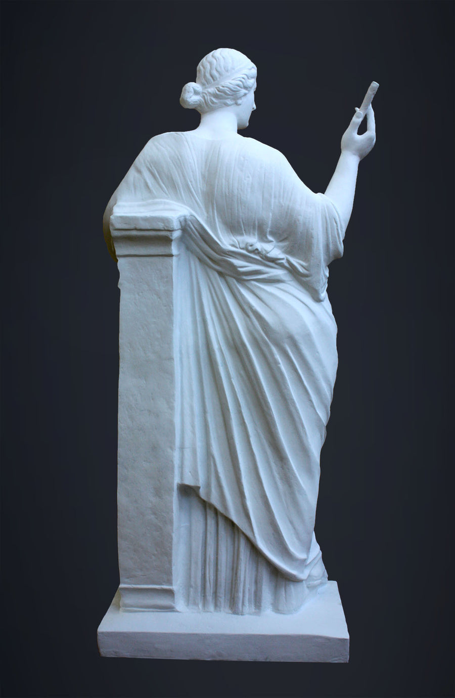 photo of plaster cast sculpture of female figure in robes leaning on podium