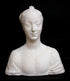 photo of white plaster cast of female bust with up-do and dress against black background