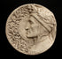 photo of plaster cast of small medallion with male portrait, namely Dante Alighieri, in profile and floral decoration on the left side curve and the word Dante, on black background