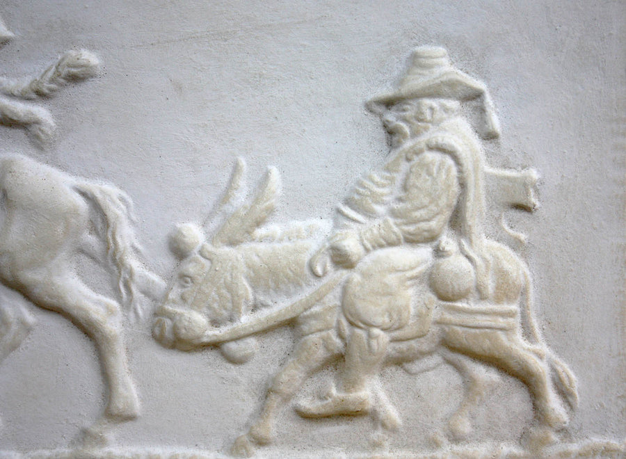 closeup photo of plaster cast relief sculpture of man riding donkey in profile