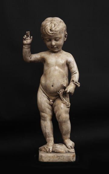 photo of plaster cast sculpture of nude male child, namely Christ, with raised right arm on a black background