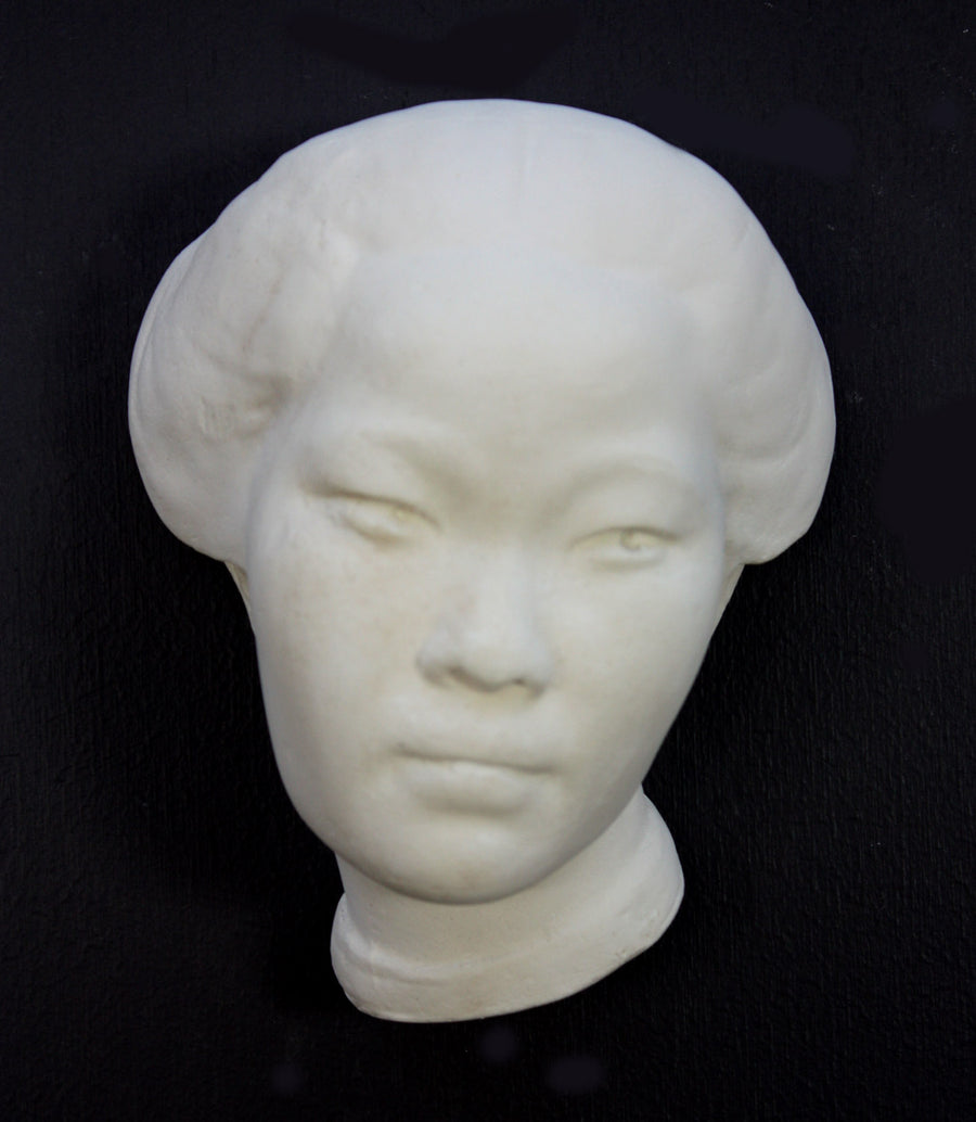 Photo of plaster cast of face of Chinese female on a black background