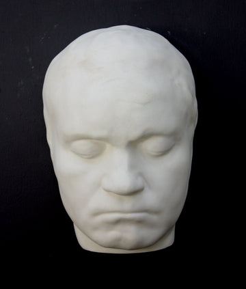 Photo of sculpture of life mask of Beethoven on a black background