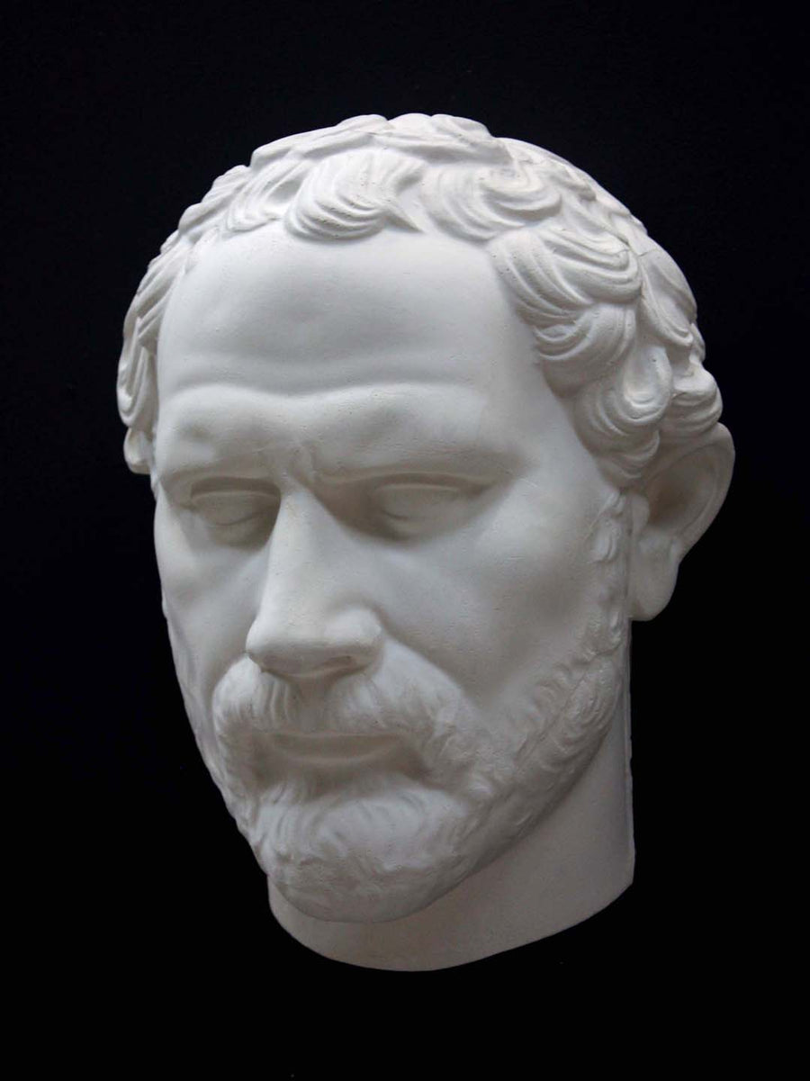 photo of white plaster cast of sculpture of face of Demosthenes with curly hair and beard on black background