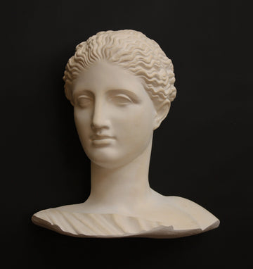 photo of plaster cast of ancient female bust, namely the goddess Diana, with a black background