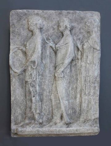 photo of plaster cast sculpture relief with figures walking to the left on gray background