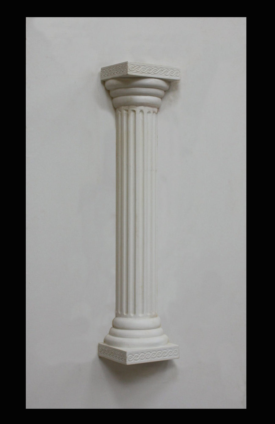 photo of plaster cast sculpture of Greek half column on a white panel