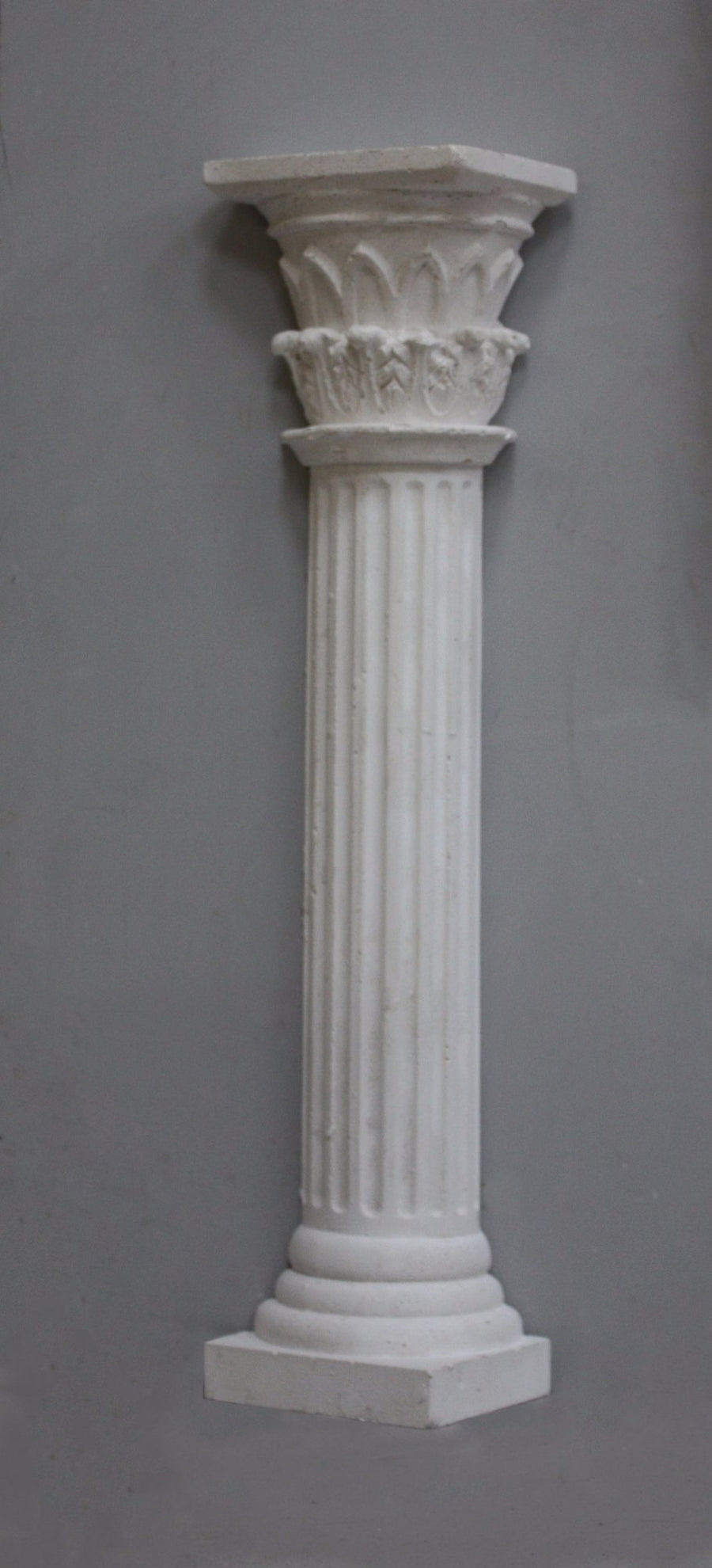 Photo of plaster cast sculpture of Greek half column on a grey background