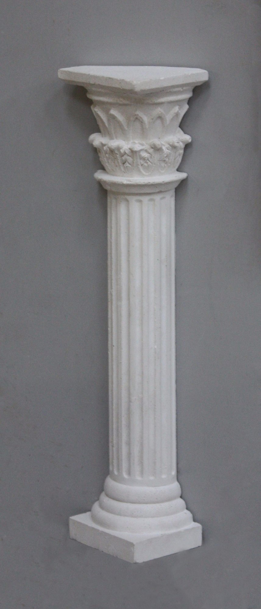 Photo of plaster cast sculpture of Greek half column on a grey background
