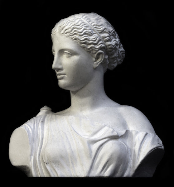 photo of plaster cast of ancient female bust, namely the goddess Diana, with a black background
