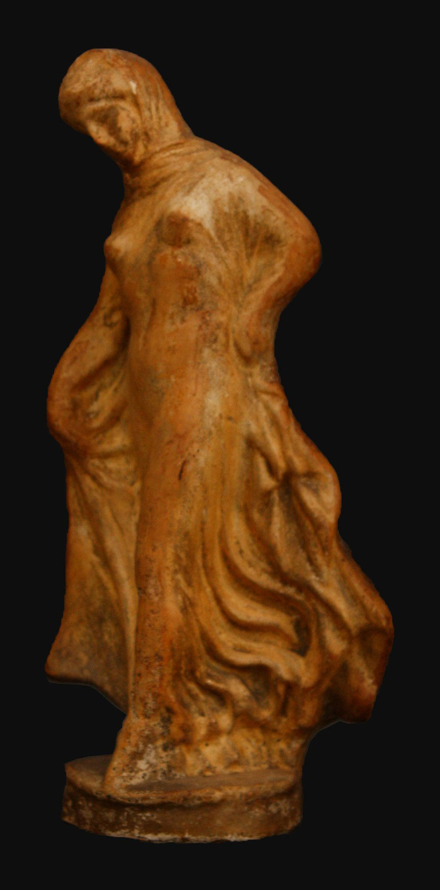 photo with black background of terracotta female dancer in flowing drapery