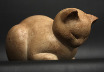 photo of tan-colored plaster cast sculpture of sleeping cat