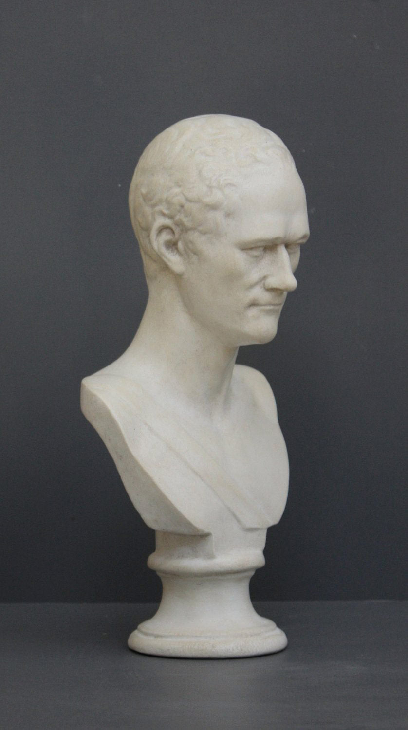 photo of white plaster cast bust of man, namely Alexander Hamilton, against gray background