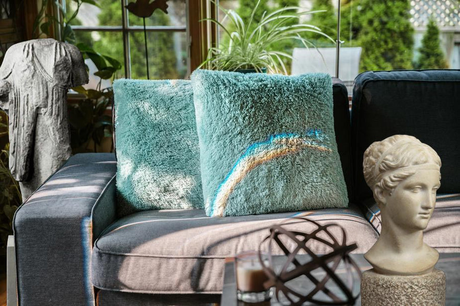 Photo of Plaster Cast sculpture bust of goddess Hebe on a coffee table with a couch with green pillows, plants and a plaster statue of Kore in the background