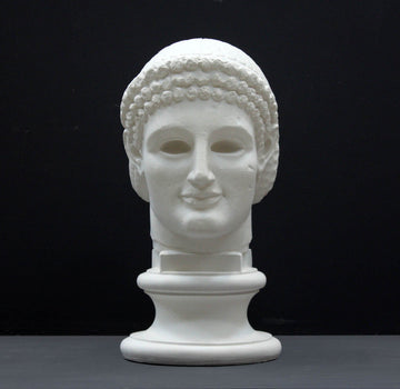 photo of plaster cast sculpture of archaic Greek male head with hair in fillet and ringlets on dark gray background