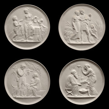 photo of four off-white plaster cast relief sculptures of male and female figures, children, cats, and dogs figuratively depicting the four seasons against black background