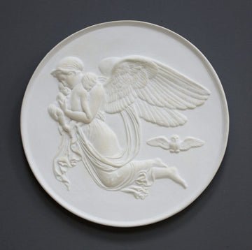 photo of plaster cast relief of woman with wings flying with two children nestled against her and an owl flying on a dark background