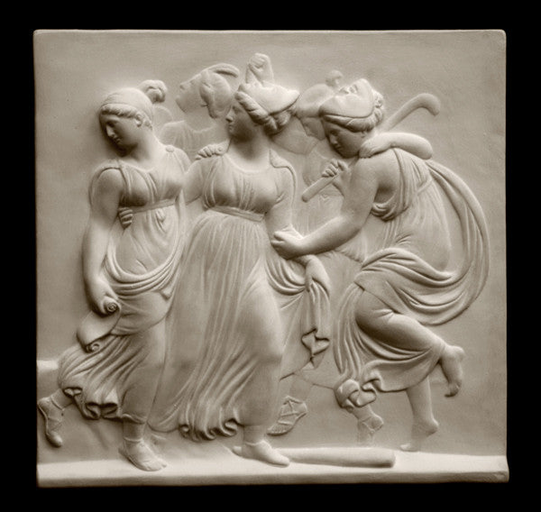Photo with black background of plaster cast sculpture relief of females dancing