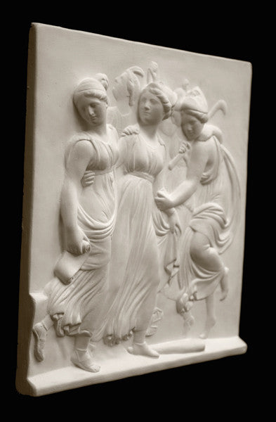 Photo with black background of plaster cast sculpture relief of females dancing