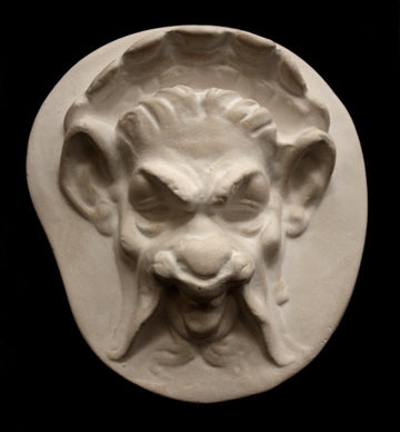 Photo of plaster sculpture of a Faun Head on a black background