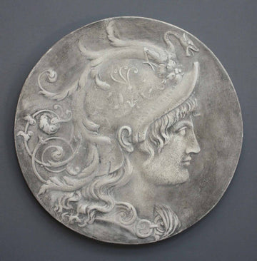 photo of relief plaster cast with profile portrait of the goddess Minerva hanging on a gray-colored wall