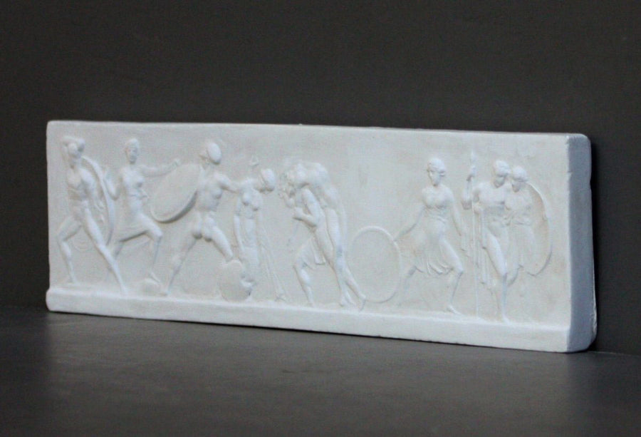 photo with gray background of plaster cast of small ancient relief sculpture with figures
