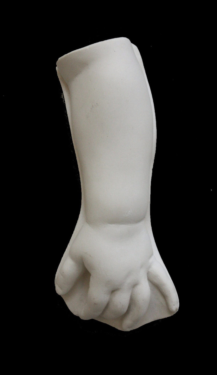 photo of white plaster cast sculpture of baby lower arm against black background